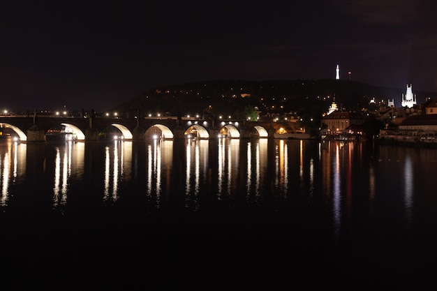 Ponte noturna sobre o rio com lanternas em Praga, República Checa