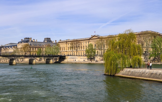 Ponte pedonal pont des arts sobre o rio Sena e edifícios históricos de paris, frança