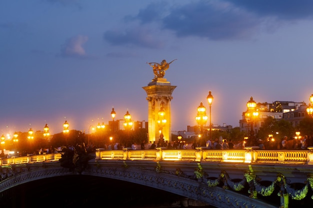 Ponte Pont Alexandre III e postes de luz iluminados ao pôr do sol 7º Arrondissement Paris França