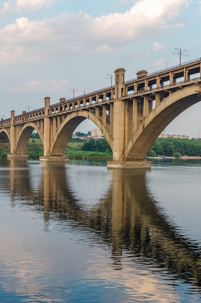 Ponte rodoviária e ferroviária de dois níveis sobre o rio em um fundo de céu azul na cidade