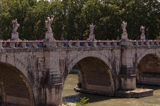 Ponte Sant'Angelo sobre o rio contra as árvores