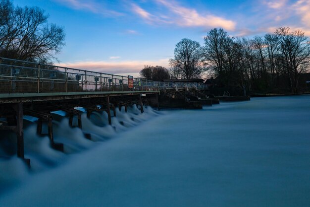 Foto ponte sobre o canal contra o céu durante o pôr do sol