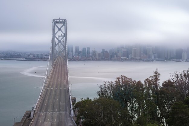 Foto ponte sobre o rio com a cidade ao fundo