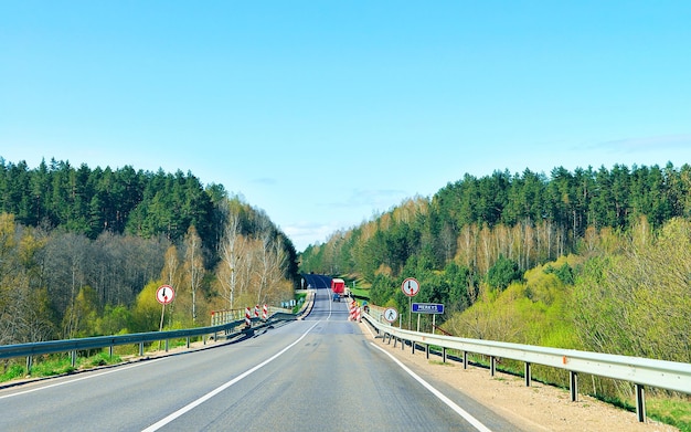 Ponte sobre o rio na estrada na zona rural. floresta ao fundo