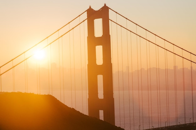 Foto ponte suspensa contra o céu durante o pôr do sol