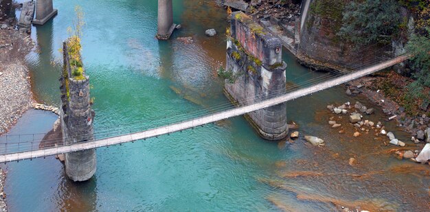 Ponte suspensa para pedestres no rio da montanha