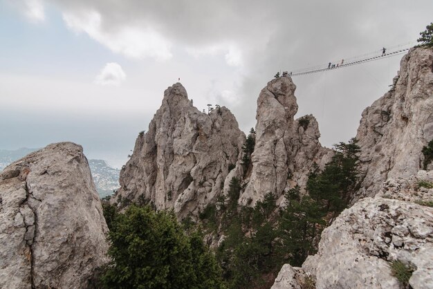 Ponte suspensa sobre o cânion no topo da montanha AiPetri na Crimeia Turistas viajantes que desejam adrenalina e sensações perigosas