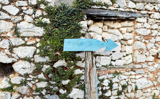 Ponteiro antigo para a direita em um fundo de um muro de pedra