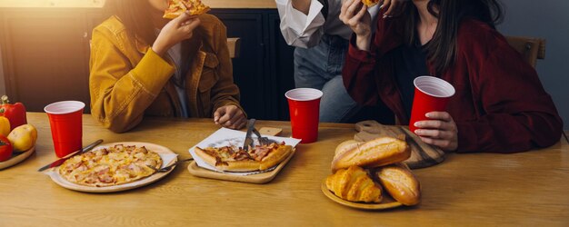 Ponto de encontro de amigos Jovem fêmea comemorando festa de aniversário no fim de semana em casa comendo pizza bebendo champanhe festa estilo de vida amizade