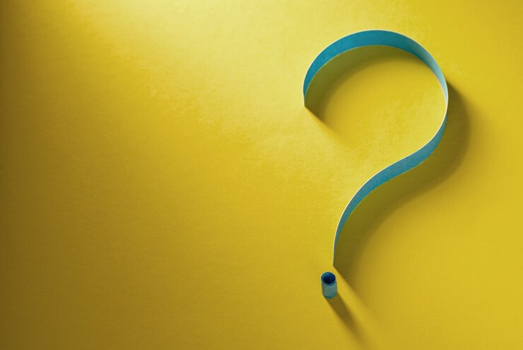 Foto ponto de interrogação de papel azul enrolado em um fundo amarelo colorido