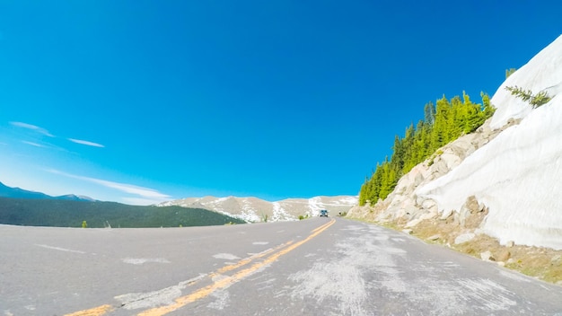 Ponto de vista do POV - dirigindo na estrada alpina do Monte Evans no início do verão.