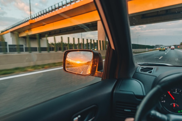 Ponto de vista em primeira pessoa pôr do sol no espelho do carro