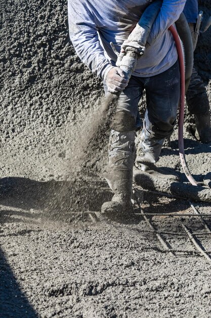 Foto poolbauarbeiter schießt betonspritzbeton oder spritzbeton durch schlauch