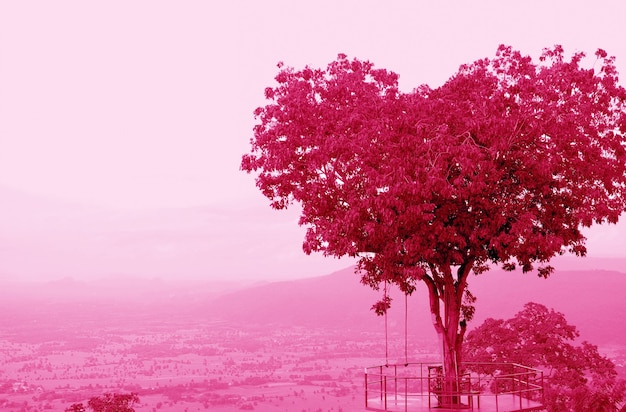 Pop Art estilo surrealista árbol en forma de corazón contra el cielo nublado en tono de color magenta