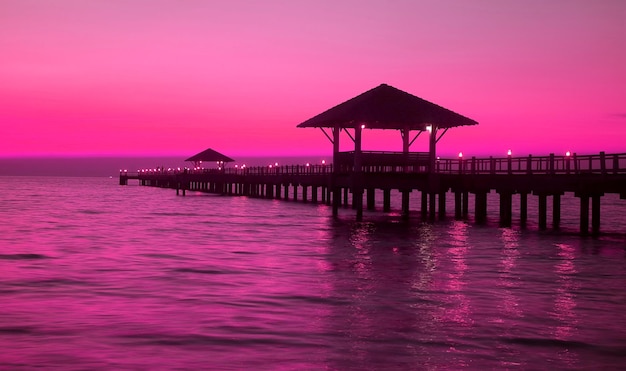 Pop-Art-Silhouette des Holzpavillons auf dem Pier bei Sonnenuntergang in lebhaftem violettem Rosaton