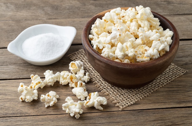 Popcorn auf einer Schüssel mit Salz und Soda über Holztisch