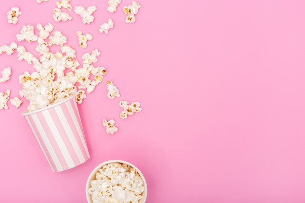 Popcorn-Eimer auf rosa Hintergrund. Film- oder TV-Hintergrund. Draufsicht Speicherplatz kopieren