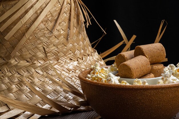 Popcorn-Erdnussbonbons serviert in einem Topf mit Strohhut auf Holzhintergrund