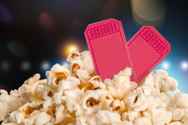 Popcorn-Essen in Schachtel und Tickets auf unscharfem Hintergrund