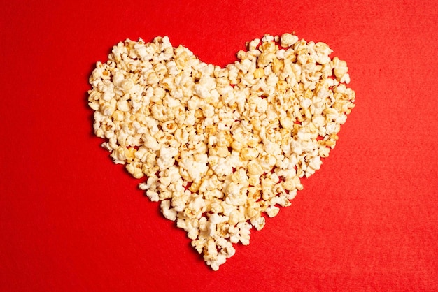 Popcorn-Herz auf rotem Hintergrund Lieblingsessen romantisches Essen oder Snack zum Valentinstag Popcorn fo