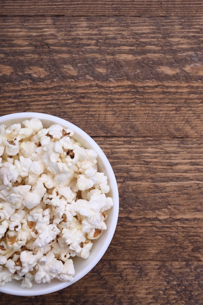 Popcorn in der Schüssel auf einem roten Hintergrund. Nahansicht. Draufsicht.