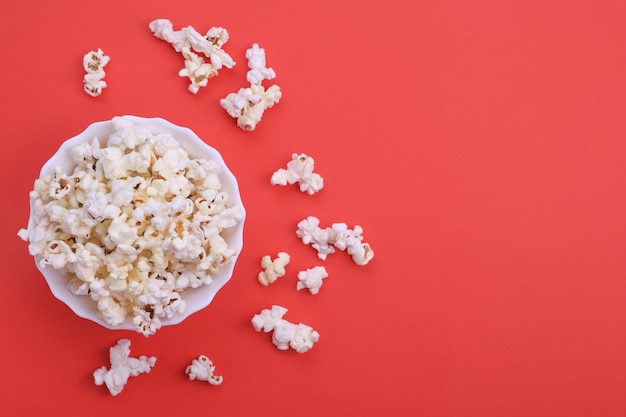 Popcorn in der Schüssel auf einem roten Hintergrund