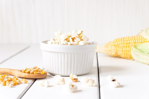 Popcorn Maiskolben und Maiskörner auf weißer Tischplatte