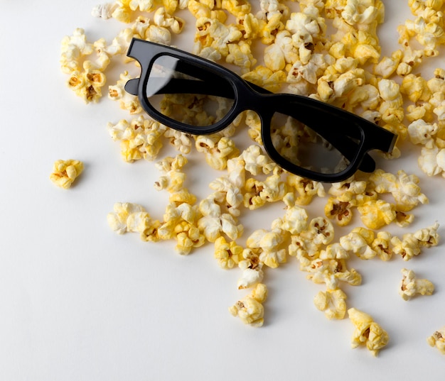 Popcorn und 3D-Gläser am weißen Tisch.