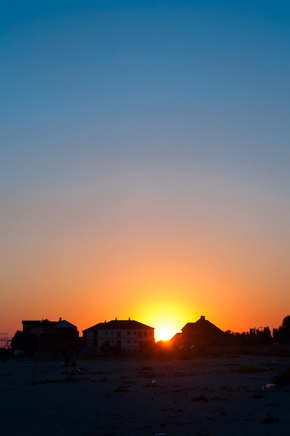 Pôr do sol atrás das casas e nuvens