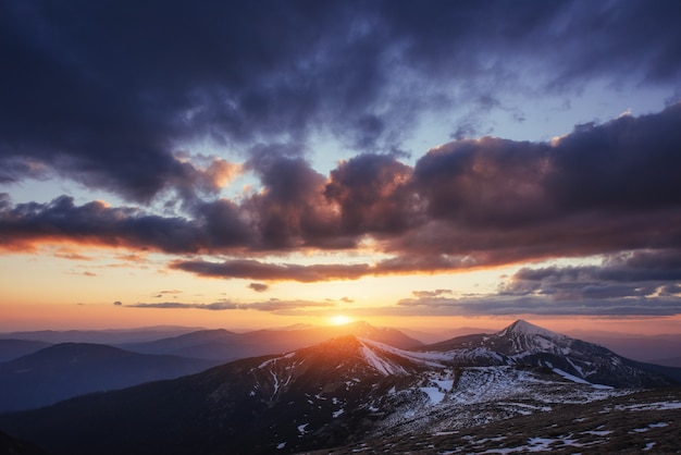 Pôr do sol colorido da primavera sobre as cadeias de montanhas no nacional