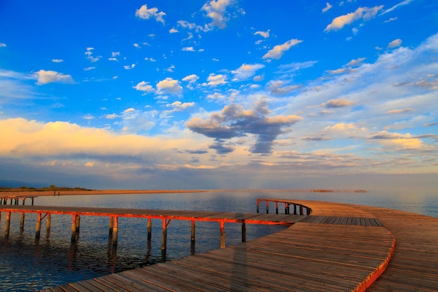 Pôr do sol colorido no mar Lago de montanha nos raios do sol laranja Quirguistão Lago IssykKul fundo natural