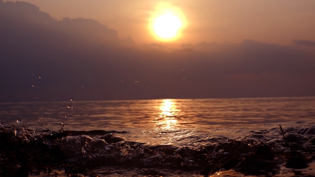 Foto pôr do sol com água do mar ondulante