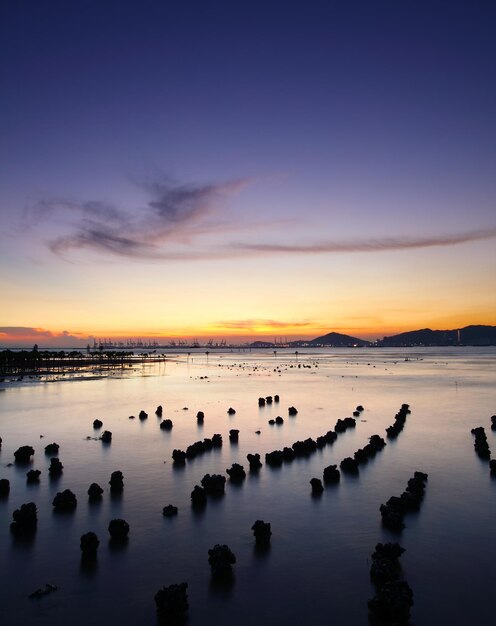 Pôr do sol com mar e pedra