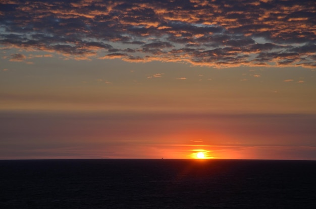 Pôr do sol com nuvens no mar