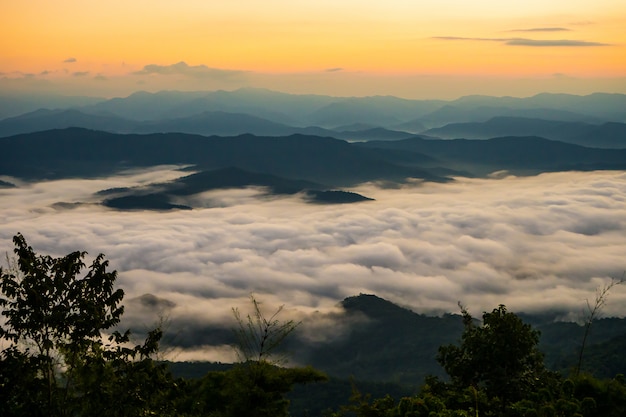 pôr do sol com vista para as montanhas com névoa