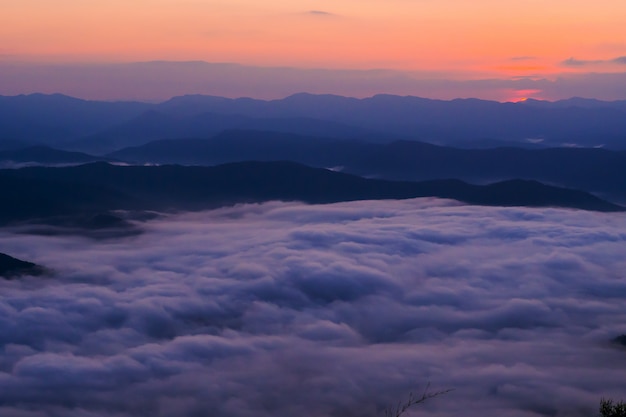 pôr do sol com vista para as montanhas com névoa