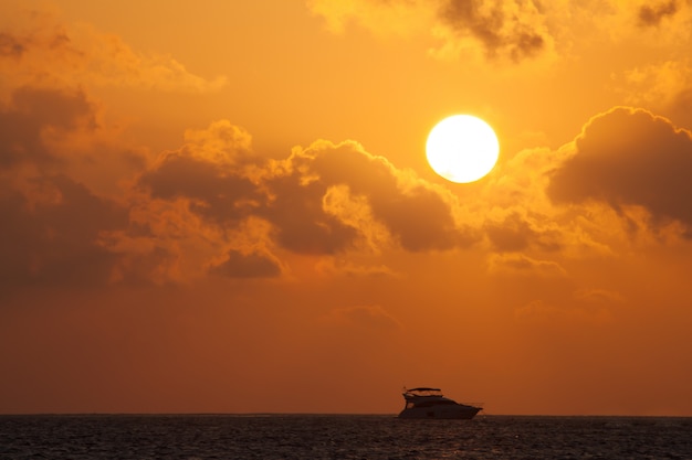 Pôr do sol com vista para o oceano com barcos