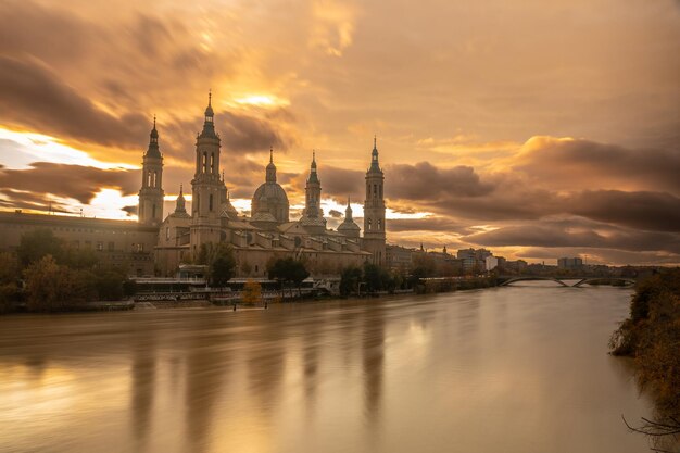 Pôr do sol da ponte de pedra ao lado da basílica de nuestra señora del pilar