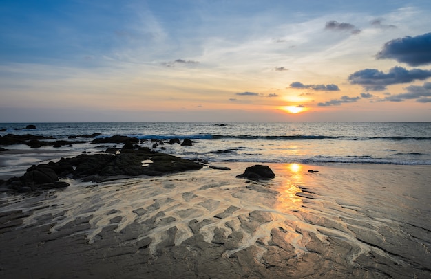 Por do sol da praia da rocha com skyline bonito do cloudscape