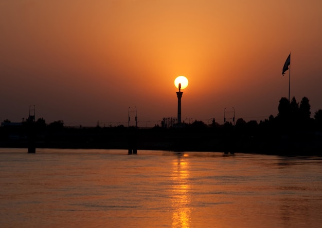 Pôr do sol de colorfull na margem do rio no contexto da cidade vazia