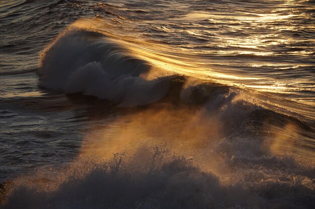 Foto pôr-do-sol de outono contemplando o mar as ondas os penhascos e as cores do sol no oceano