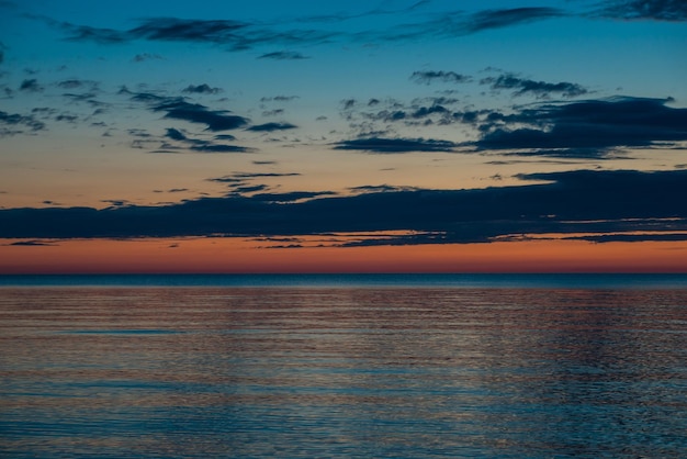 Pôr do sol de verão na praia com nuvens no céu