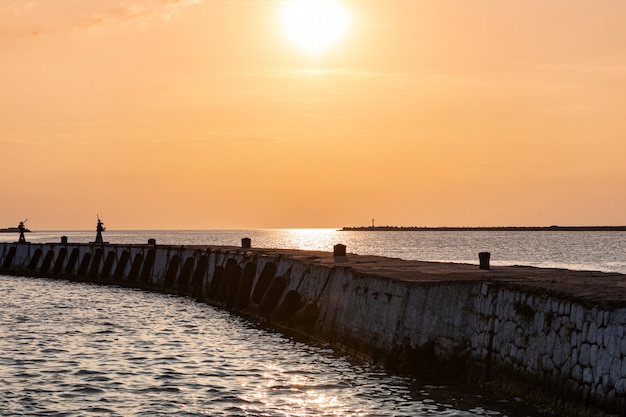 Pôr do sol do mar sobre o cais do báltico. sonhos de viagem e liberdade. bela vista do cais