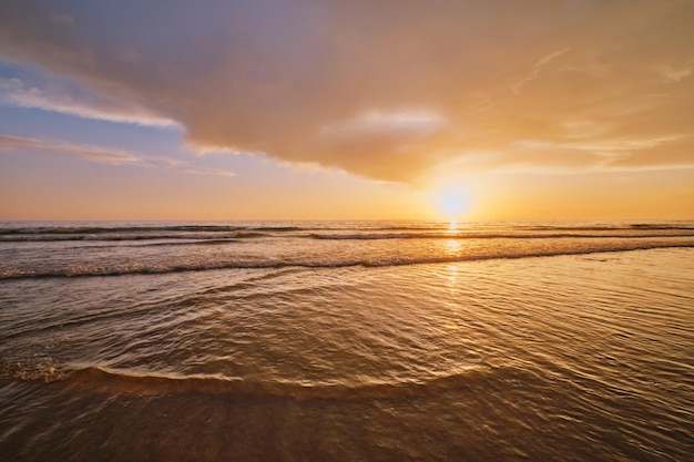 Pôr do sol do oceano Atlântico com ondas na praia da fonte da telha portugal