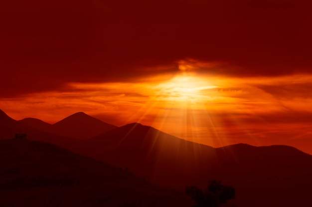 Pôr do sol dourado dramático com sol e cordilheira