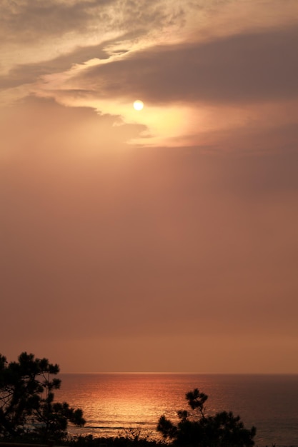 Pôr do sol dourado sobre as águas calmas do Oceano Atlântico.