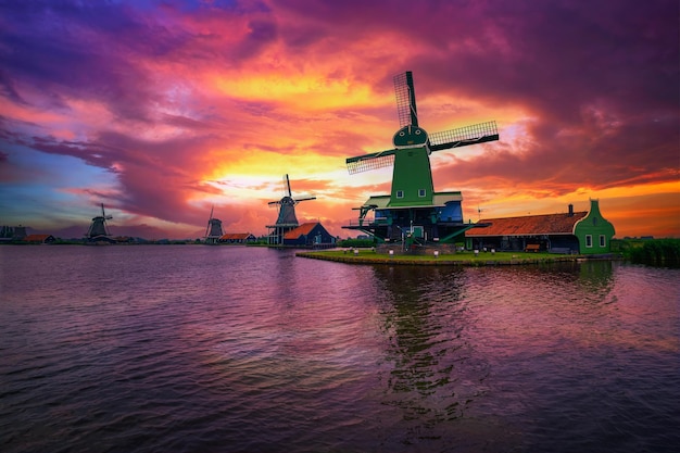 Pôr do sol dramático acima de casas de fazenda e moinhos de vento de zaanse schans holanda