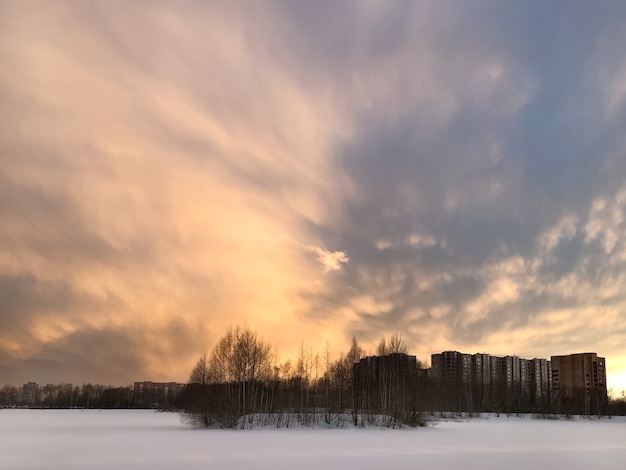 Pôr do sol dramático sobre a paisagem de inverno do lago coberto de neve