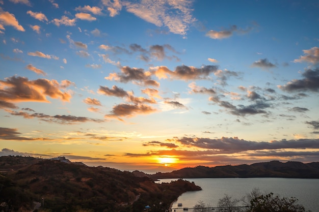 Pôr do sol dramático sobre o mar com colinas