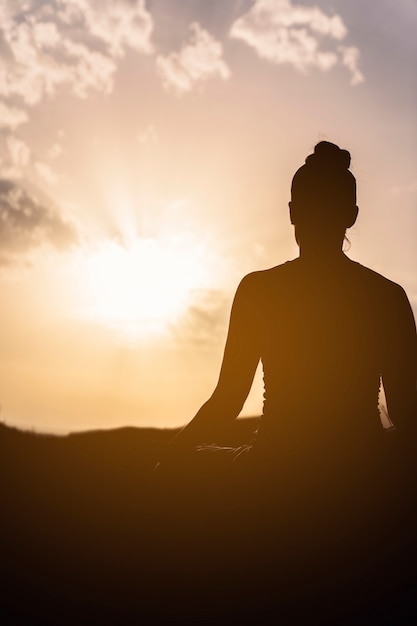 Foto pôr do sol e mulher meditando